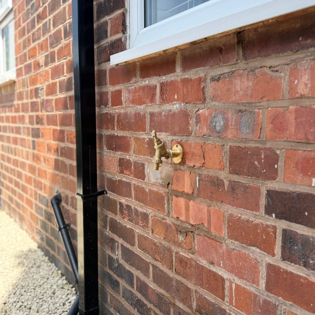 Outside tap fitted to a brick wall with isolation valve