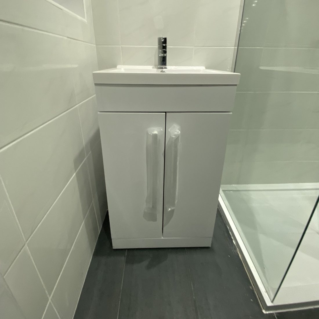 Wall-hung vanity unit and basin alongside a new shower enclosure